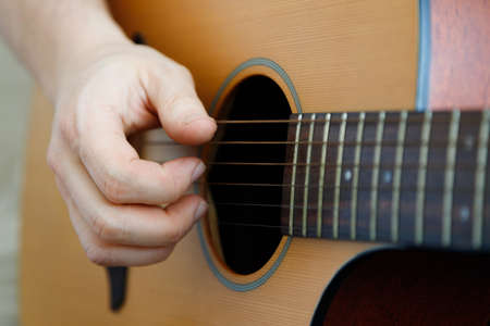 Close-up of a male hand playing a guitar. Learning music. Fun, live music