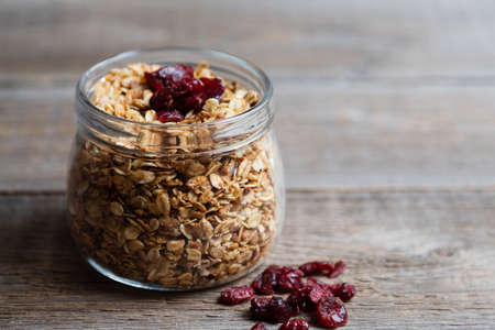 Glass jar with homemade granola and dried berries. Granola as the right breakfast for the whole...