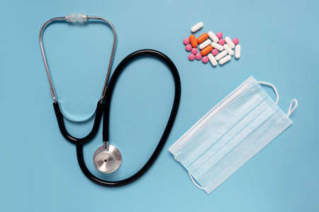 Medical concept. Mask, stethoscope and a handful of medicines, pills or pttle. Disease treatmentの写真素材
