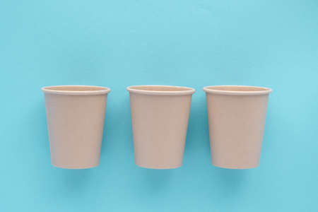 Three eco-friendly bamboo reusable cups on a blue background. Environmental protection, no wasteの写真素材