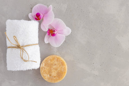 Concept for spa salon, face and body care, massage room or beautician. White bath towel and orchid. Copy spaceの写真素材