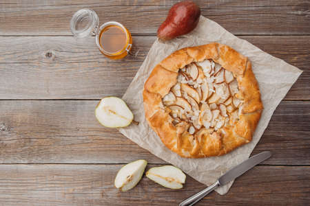 Homemade rustic cake from caramelized pears with walnut on a wooden table, top view. A simple and tasty dessert. Place for text.の写真素材
