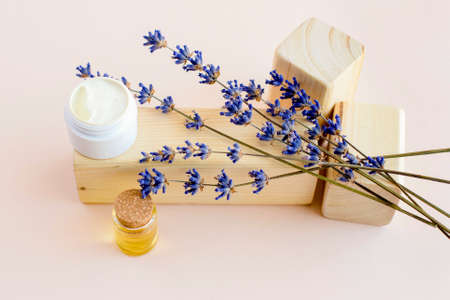 The concept of natural cosmetics with the addition of herbs. Jars of facial and body care cosmetics next to essential oil and dried lavender flowers. Trendy neutral tones. Copy space.の写真素材