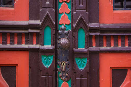 Vintage dark red antique double door in Paris. Round handle on aged wood surfaceの写真素材