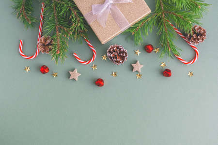 Christmas background from Christmas candies, branches of a Christmas tree, toys and cones with a...