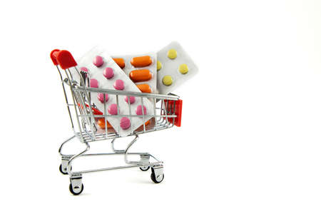 Medical concept. Various pills, pills and capsules in a shopping cart on a white background. Buying medicine. Buying and selling tablets and pills. Place for text.の写真素材