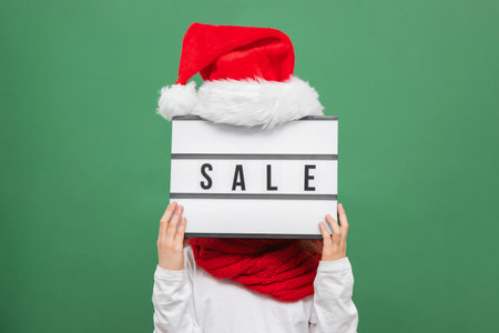 Sale, Christmas and New Year shopping. A girl with a sale sign instead of a head. Faceless trend. Online shopping during the sales period. Close-up portrait.の写真素材