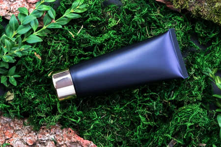 Cosmic mock ap. A tube of garlic with a gold cap rests on natural materials. Eco-friendly, bio cosmetics, personal care productsの写真素材