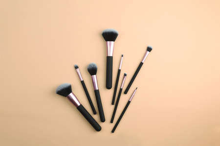 A set of makeup brushes on a beige background. Brushes for applying cosmetics. Cosmetology, make-up....