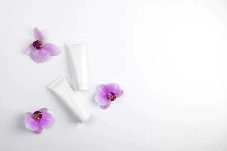 Cosmetic mock-up. White tubes with cream or lotion and a white towel next to it. Treatment in the spa salon. Cosmetic procedures. Copy spaceの写真素材