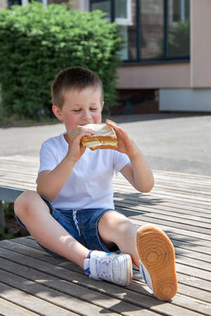 Healthy food for children at school. The boy eats a homemade sandwich, lunch or snack in the school...