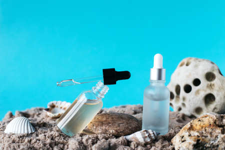 Bottles of serum, hyaluronic acid on stones and sand. Place for your text. Skin care