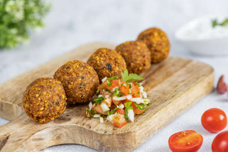 Falafel, a traditional Middle Eastern dish made from chickpeas, served with tomato salad. Vegetarian food. Great healthy snack. Close-upの写真素材
