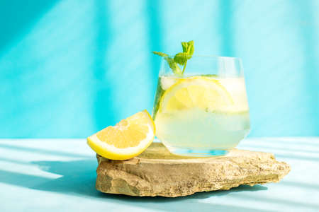 Fresh detox drink with cucumber and lemon slices, with mint in the hard rays of the sun. Summer cocktail. Healthy food conceptの写真素材