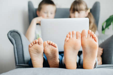 Children study online at home or make a video call through a laptop. Communication with friends in...