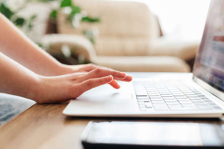 Close-up of the girls hands on the laptop keyboard. Children use technology to learn and communicate...