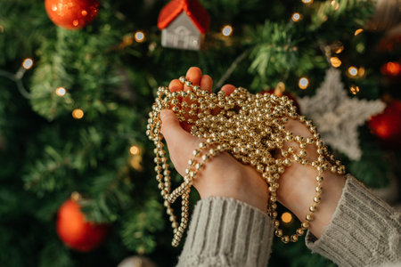 Close-up of a childs hands holding a Christmas tree garland. Holiday home decoration