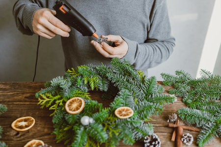 The hands of a male florist makes a New Years drenching from fresh spruce branches, cones and dried fruits. New Years master classの写真素材