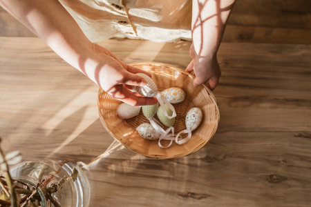 Close-up of a girls hand taking out Easter textile eggs for home decoration. Preparation for the holiday. Happy easterの写真素材