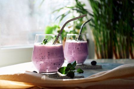Blueberry homemade fresh smoothie on the table in the bright rays of the summer sun.Healthy food...