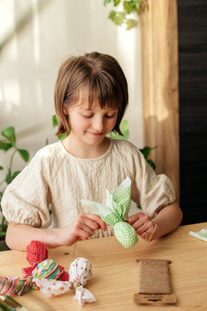 Making Easter decorations. A girl makes a textile Easter egg at home in the shape of a bunny, bunny. home decorationの写真素材