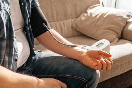A man measures his blood pressure at home using a tanrometer and a measuring cuff. The concept of...