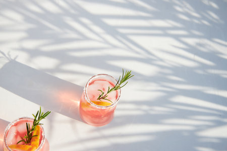 Top view of fresh grapefruit or red orange cocktails, with ice cubes, fresh fruit slices inside and rosemary. Vacation and summer cocktails concept. Citrus drink.の写真素材
