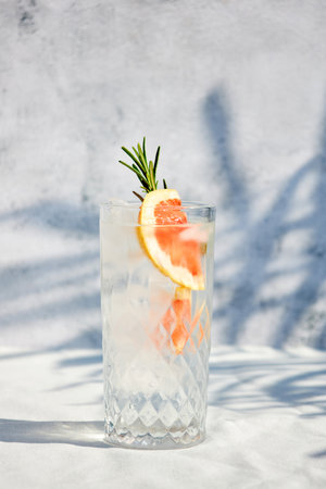Summer chilled grapefruit cocktail with ice and rosemary sprig. Summer cold drinks. Soda with citrusの写真素材