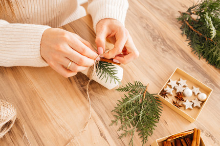 Close-up of a girls hands decorating candles with New Year or Christmas decor. Woman creates holiday decorations, candles for home.の写真素材