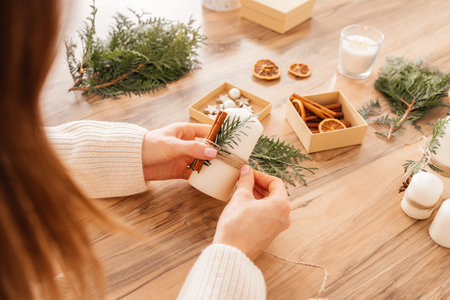 Close-up of a girls hands creating decorations for Christmas and New Year. Handmade gifts. Decorations for the home for the holiday. Candle decoration.の写真素材