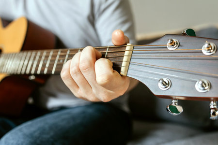 Close-up of a mans hands playing the guitar and strumming chordsの写真素材