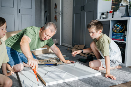 Father and children assembling furniture together, family diy project