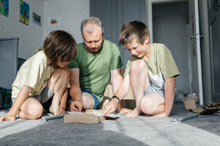 Father and sons assembling furniture following instructionsの写真素材