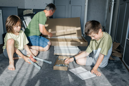 Father and sons assembling furniture, learning diy skillsの写真素材