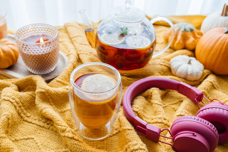 Autumn tea time with headphones and pumpkins enjoying hygge