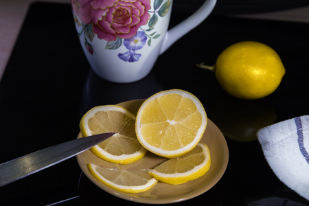 Sliced lemon with plate on black background. Still life with lemons.の写真素材