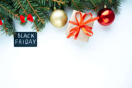 Black Friday big sale promotional sign on white background with fir branches, Christmas balls and gift. Special discount offer. Top view, copy space for text. Advertising message. Holiday shopping.の写真素材