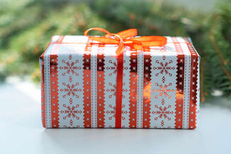 Gift with red ribbon, New Year and Christmas present. Happy New Year. Christmas background with gift box. Christmastime celebration. Copy Space for text. Selective focus.の写真素材
