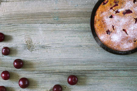 Beautiful delicious plum cake and scattered juicy plums on a wooden background, top view, place for textの写真素材