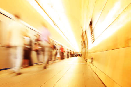 Motion blurred commuters walking in subway station.の写真素材