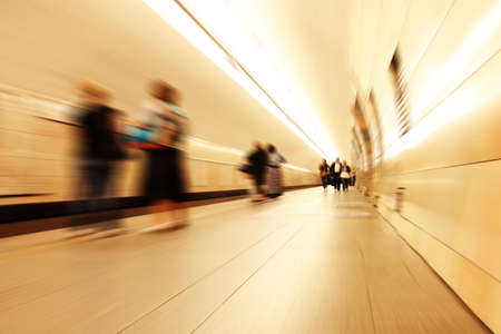 Motion blurred commuters walking in subway station.の写真素材