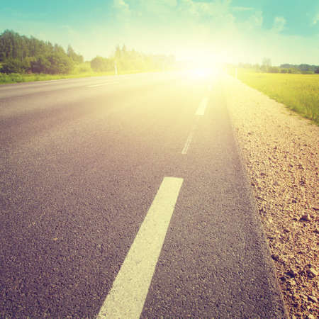 Asphalt country road at sunset. Vintage image.の写真素材