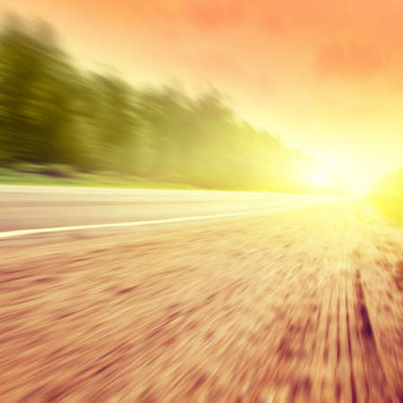 Country asphalt road in motion blur at sunset.