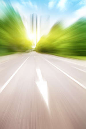 Motion blurred road with traffic sign at sunset.の写真素材