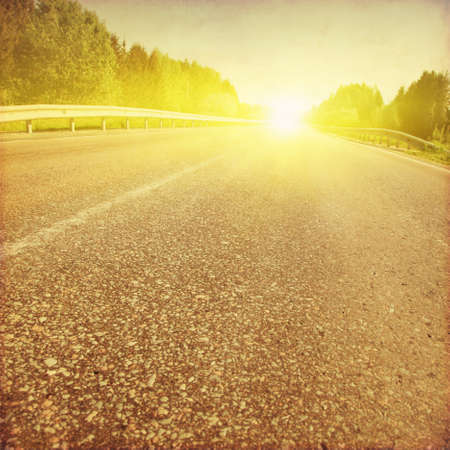 Empty asphalt road at sunset in grunge and retro style.の写真素材