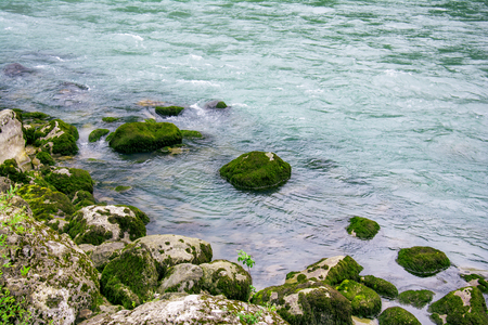 river boulders covered with bright beautiful noble green mossの写真素材