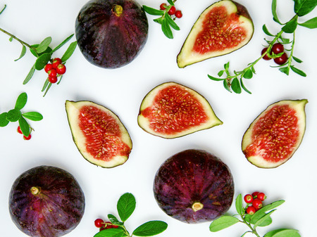 juicy figs, pieces on top, twigs and red berries of forest cranberries