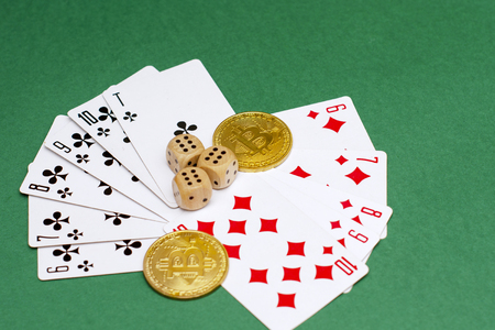 objects of a poker game - game cards, game dice and gold bitcoins on a green backgroundの写真素材