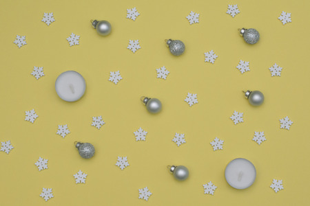 Christmas lights, wooden snowflakes and glass toy on a yellow background. flay