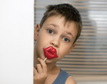 surprised boy playing put his lips on a stick to his lipsの写真素材